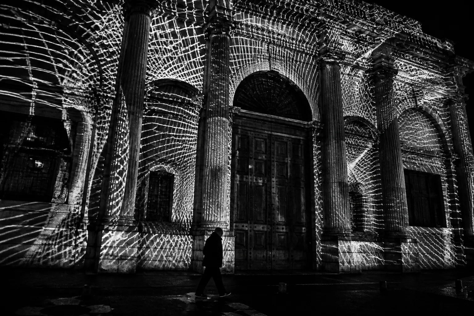 Sidewalk installation at night, in black and white